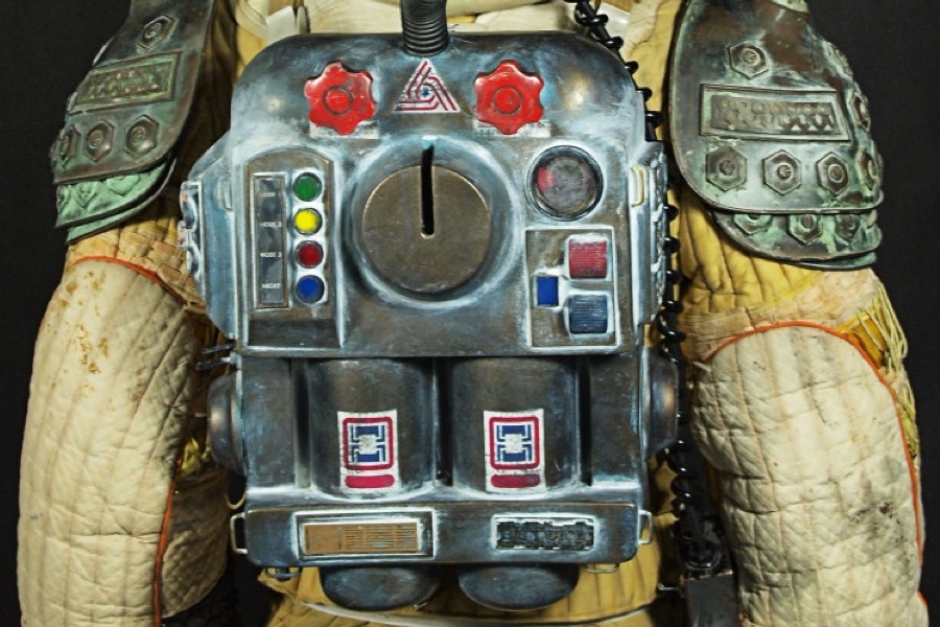 <p><strong>Figure 2.3</strong> A decal of the Tricentennial symbol can be seen on the back of portable life support units (top-center) worn with crew space suits. Source: <em>Prop Store Blog</em></p>